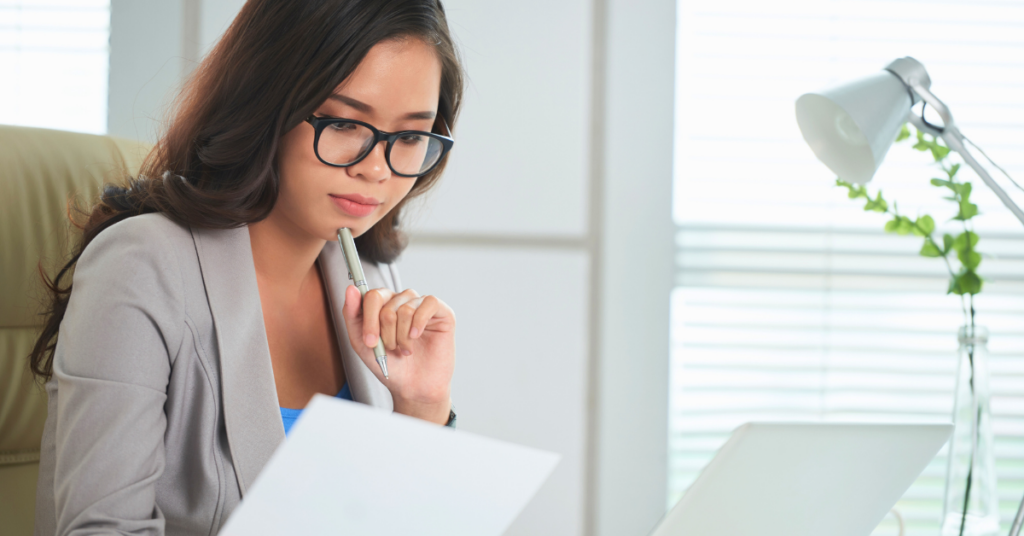 woman sitting at desk examining her sustainable investment